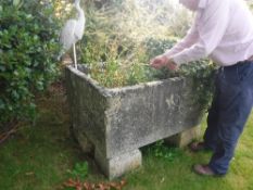 A large natural stone rectangular trough raised on four block bases,