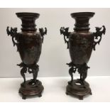A pair of Japanese Meiji period chocolate patinated bronze vases decorated in relief with birds