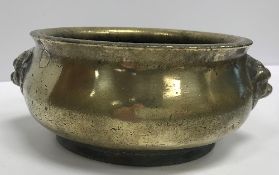 A Chinese bronze censer with stylised lion mask handles bearing faux Qianlong four character mark