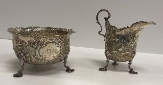 A Victorian silver sugar and cream decorated with rabbits and pheasants in landscapes,