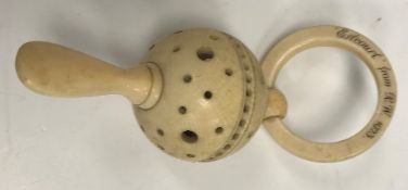 A carved ivory rattle teether inscribed "Estcourt from R.W. 1923.