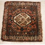 A Caucasian rug, the central panel set with lozenge shaped medallion on a salmon pink ground,