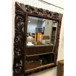 A 20th Century carved oak framed rectangular wall mirror in the Rococo style with all over