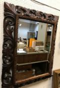 A 20th Century carved oak framed rectangular wall mirror in the Rococo style with all over