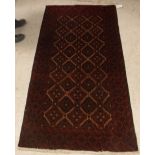 A Tekke Bokhara rug with all-over elephant foot medallions on a red ground,