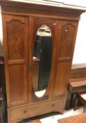 An Edwardian mahogany and inlaid single mirror door wardrobe with drawer below,