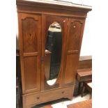 An Edwardian mahogany and inlaid single mirror door wardrobe with drawer below,