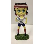 A modern painted cast iron figure of Betty Boo carrying a rugby ball,