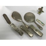 A George V silver and engine turned four piece dressing table set comprising two clothes brushes,