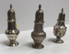 A George III silver baluster shaped pepper with flaming torch finial and pierced domed cover,