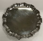 A George V silver salver in the Georgian manner with pie-crust rim,