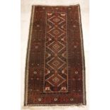 A Belouch rug, the central panel set with repeating diamond medallions on a dark ground,