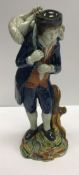 An early 19th Century Staffordshire pearlware figure of a shepherd with lamb across his shoulders