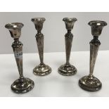 A composite set of four matching George V silver table candlesticks with beaded decoration with