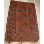 An Afghan rug, the central panel set with three repeating medallions on a burgundy ground,