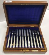 An oak cased set of twelve George V silver bladed mother of pearl handled fruit knives and forks