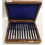 An oak cased set of twelve George V silver bladed mother of pearl handled fruit knives and forks