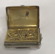 An early 19th Century silver vinaigrette of satchel form with engraved foliate decoration,