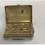 An early 19th Century silver vinaigrette of satchel form with engraved foliate decoration,