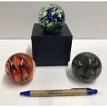 A collection of six coloured glass paperweights,