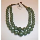A 19th Century Chinese jade two strand bead necklace, knotted and with thread fastening,