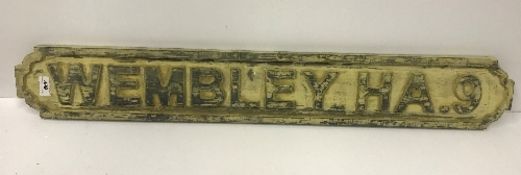 A modern wooden sign inscribed "Wembley