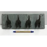 A set of four coat hooks as dogs' tails,