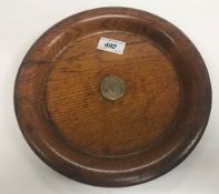 A turned oak dish bearing silver plated