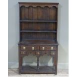 A reproduction oak small welsh dresser in early George III style the shelved back with shaped