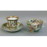 A Cantonese famille rose cup and saucer decorated in typical palette the saucer with panels of