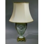 A Victorian celadon ground lamp of urnular form with applied brass caryated handles and pierced