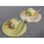 Two basket weave hat wall pockets one decorated in red and green with flowers the other polychrome