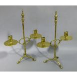 A pair of Victorian brass two arm adjustable candle sticks with broad drip pans, the posts spiral