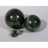 Two large and three small veined black marble spheres, modern