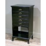 A late Victorian ebonised music cabinet of five drawers above an arched recess, outset block feet,