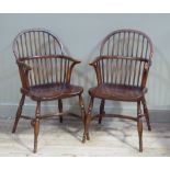 A pair of reproduction rail back Windsor elbow chairs, saddled seats on turned legs joined by