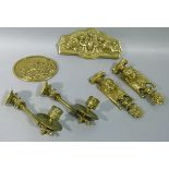 A pair of figural brass furniture mounts, a brass oval plaque, two brass candle brackets, etc