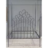 A wrought iron four poster bed with ornate headboard and arched rail base, 154cm wide