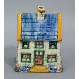 A Victorian Yorkshire cottage money box of house form, the blue and yellow roof above a front