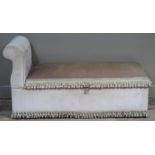 A cream dralon upholstered ottoman daybed with one scrolled arm and lift up lid, buttoned upholstery