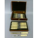 A set of twelve Victorian ivory handled fruit knives and forks contained within a fitted brown