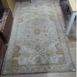A pair of Aubusson style carpets woven in a design of stylised leaves in ivory, pale sage green,