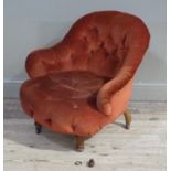 A Victorian walnut framed nursing chair upholstered in buttoned rust velvet fabric on turned legs