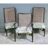 A pair of cane back chairs, stuffed over seats on square tapered legs; together with a cane back