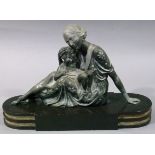 An Art Deco style white metal figure of a mother and child on an oval ended rectangular panel