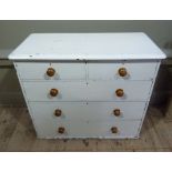 A Victorian white painted pine chest of two short over three long drawers, turned wooden handles,