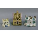 A Staffordshire Pottery cottage money box, buff pottery with under glaze black and lilac decoration,