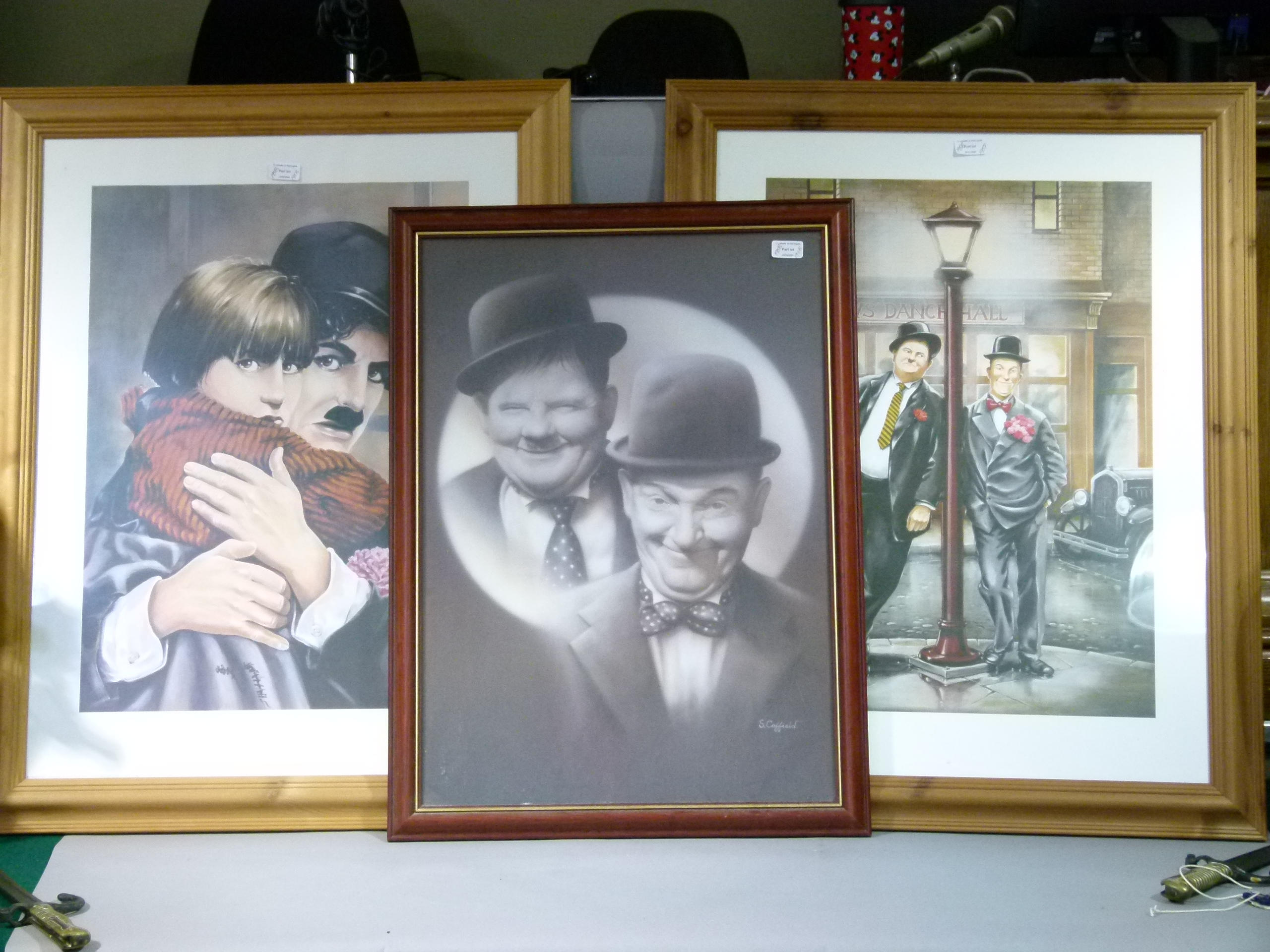 Three framed pictures of Laurel and Hardy, and Charlie Chaplin