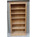 A reproduction pine open bookcase with flared cornice, adjustable shelves within moulded