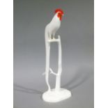 A Noritake porcelain model of an ornamental cockerel standing on a branch, rustic shaped oval